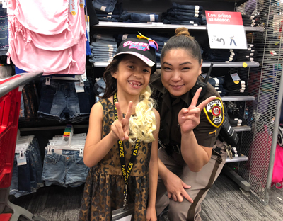 A little girl and a deputy shop at Target