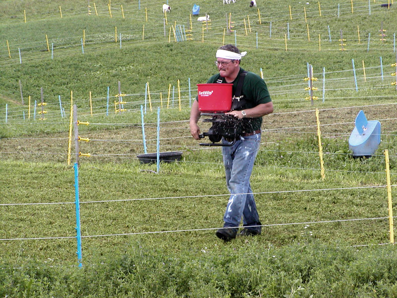 man using broadcast seeder