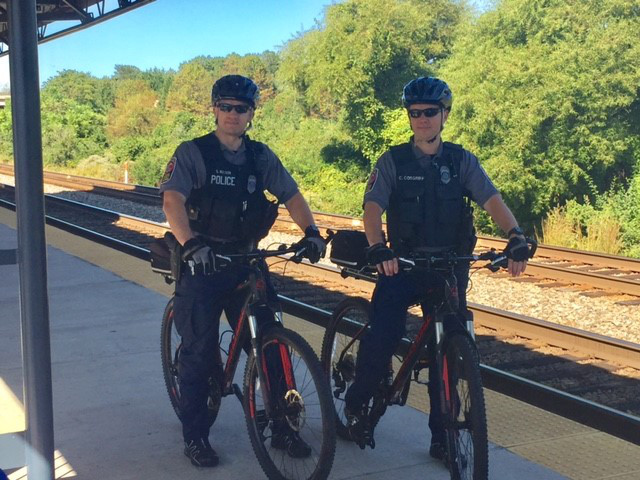 officers at train tracks on bikes